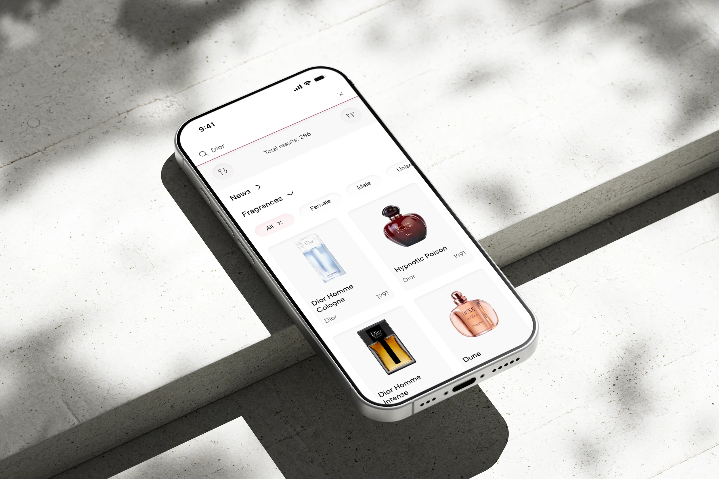Fragrantica fragrance search screen on an iPhone over a bright concrete surface