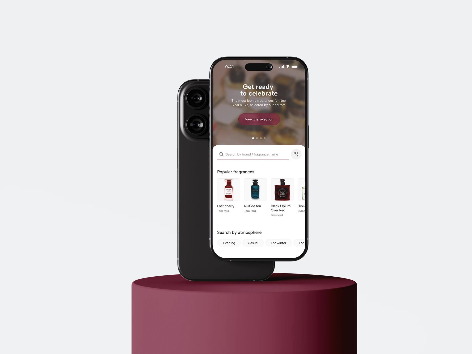 Fragrantica home screen on an iPhone beside a second phone and burgundy podium